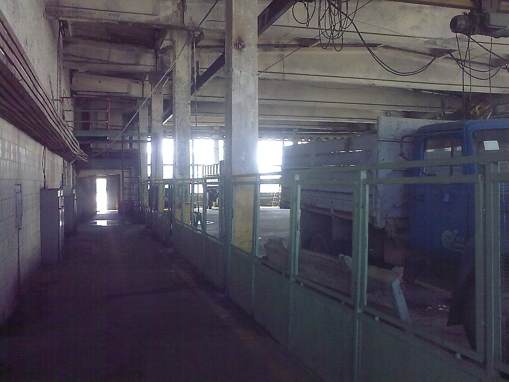 Photo from the inside of garage where the organization workers repair trucks. Building looks messy and dirty.