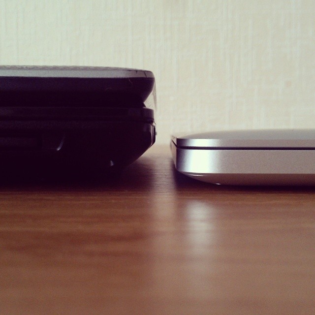 Two laptops lie near each other, one is thick, another is thin