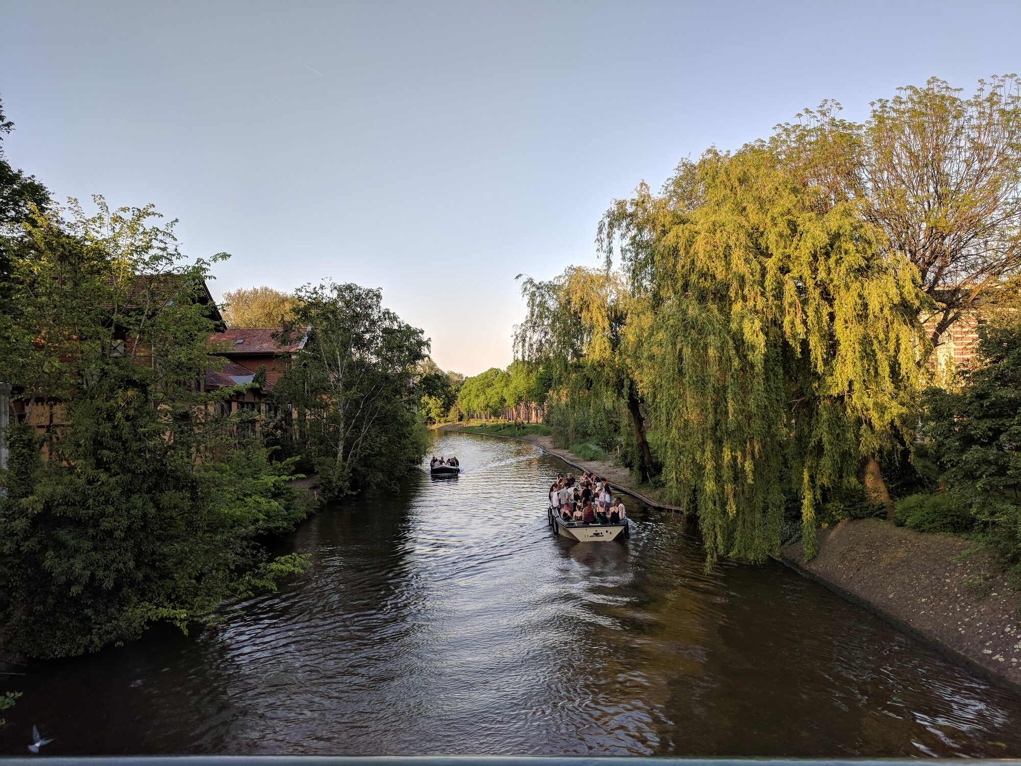 A boat on a canal with a lot of people on it partying
